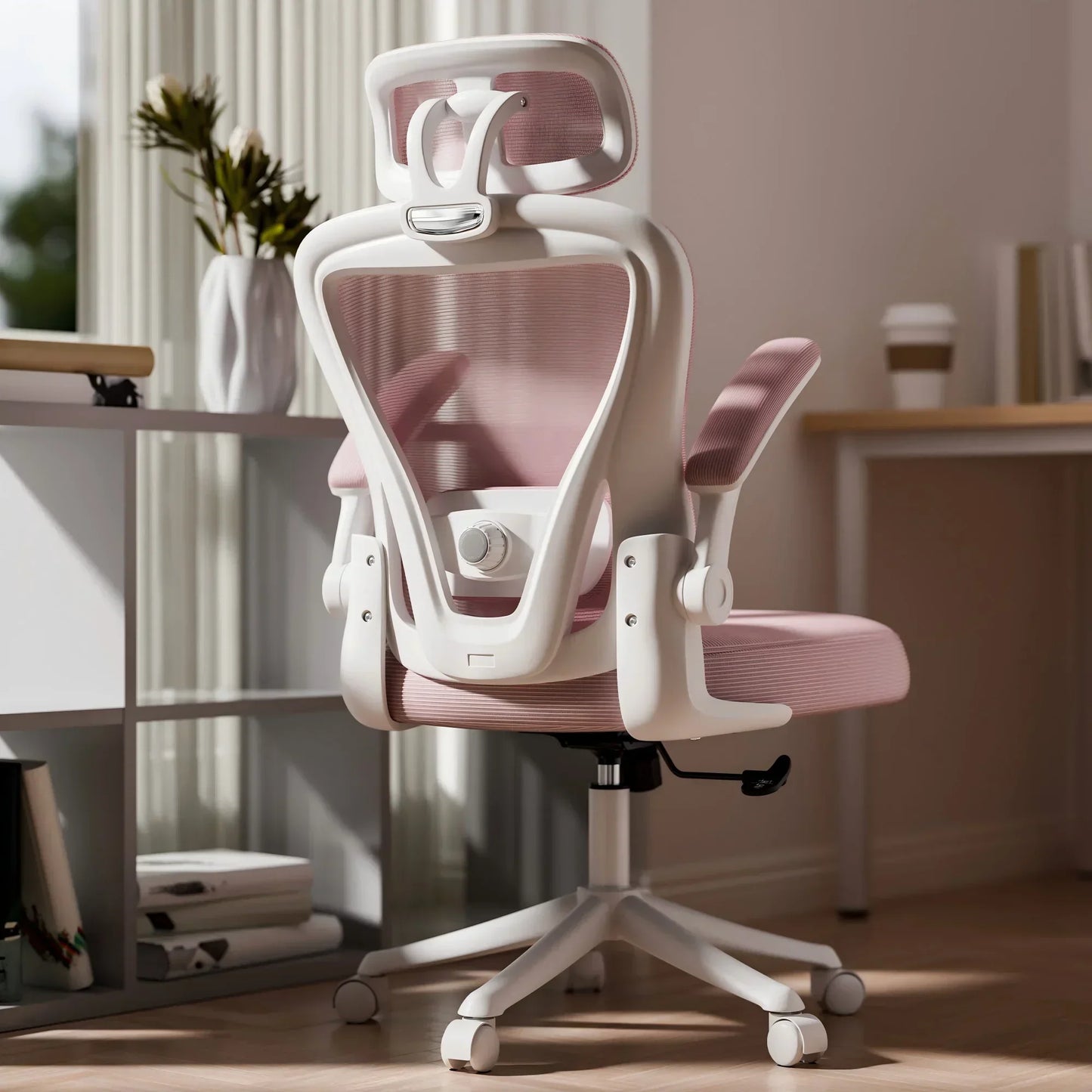 White and pink ergonomic gaming chair with mesh back, headrest, and adjustable arms in home office setup