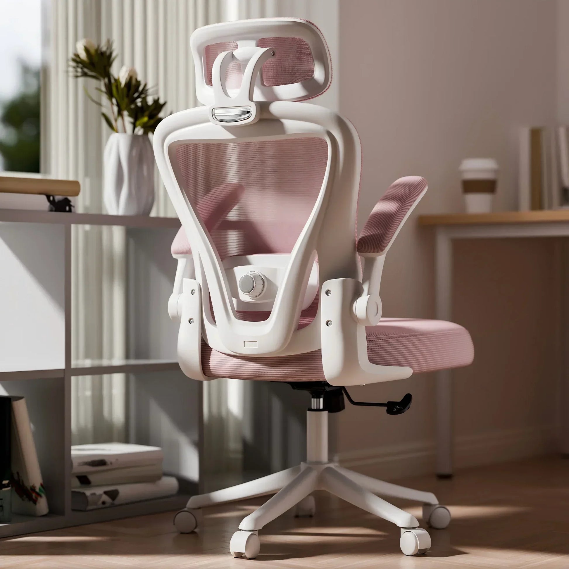 White and pink ergonomic gaming chair with mesh back, headrest, and adjustable arms in home office setup