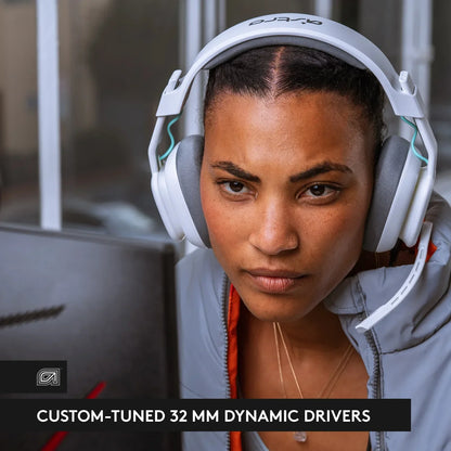 Close-up of focused woman wearing white gaming headset with microphone and light gray jacket