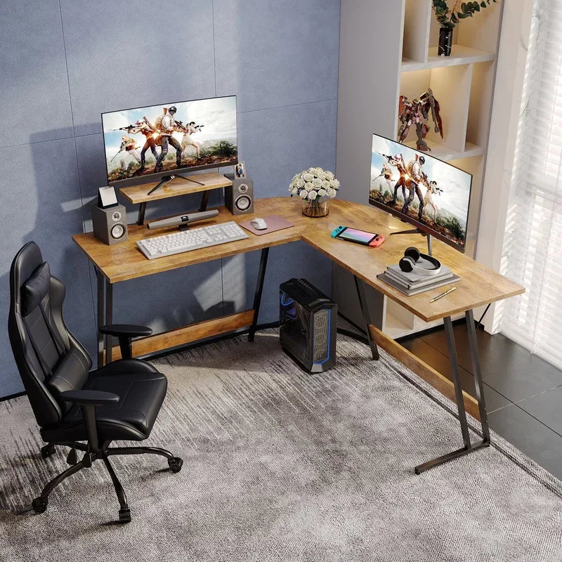 Modern L-shaped wooden desk gaming setup with dual monitors, gaming PC, black leather chair, and accessories