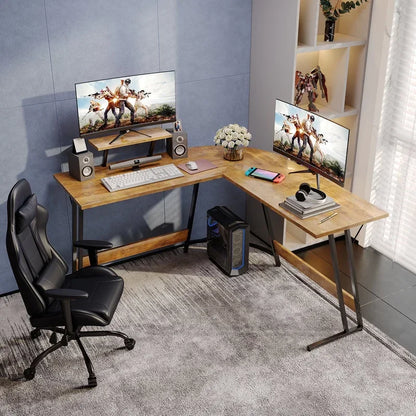 Modern L-shaped wooden desk gaming setup with dual monitors, gaming PC, black leather chair, and accessories