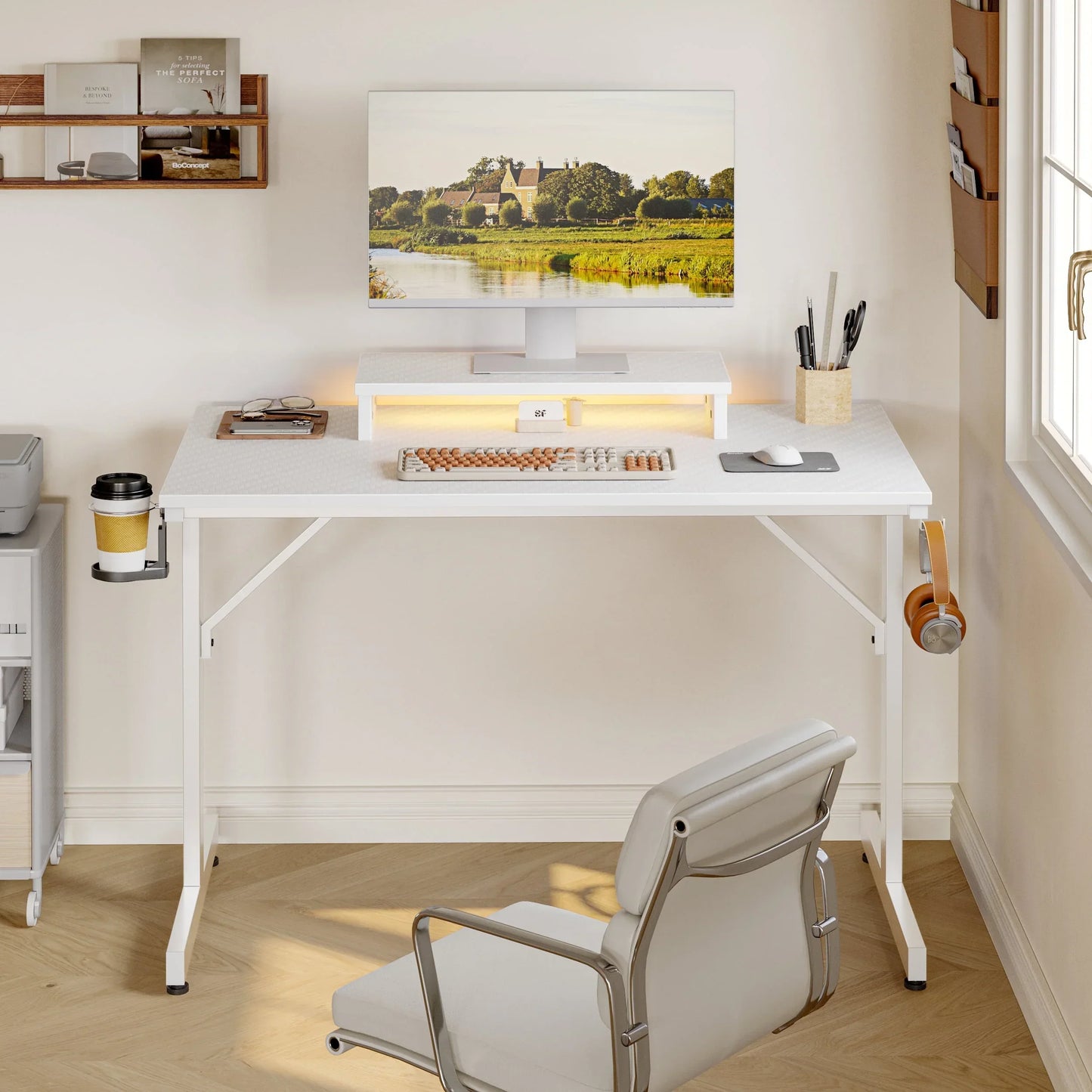 Minimalist white standing desk setup with monitor displaying countryside, mechanical keyboard, mouse, and office chair