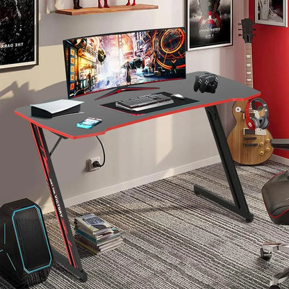 Modern gaming setup with black and red gaming desk, curved monitor, keyboard, mouse, controllers, and guitar in room