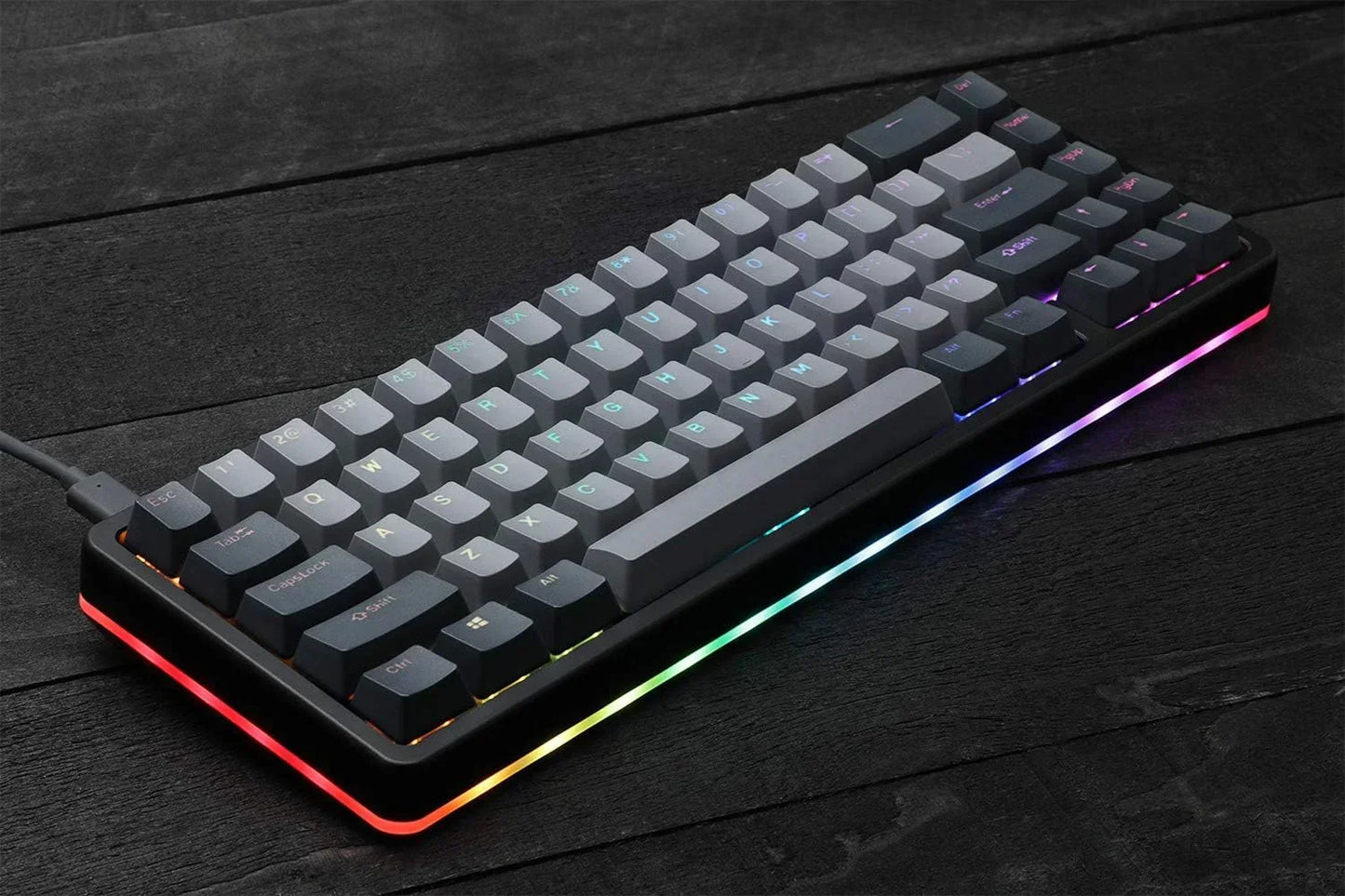 Compact mechanical gaming keyboard with RGB lighting on a dark wood desk, Byte Style gear