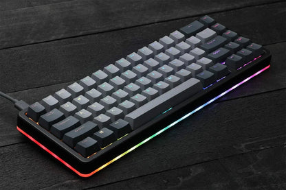 Compact mechanical gaming keyboard with RGB lighting on a dark wood desk, Byte Style gear