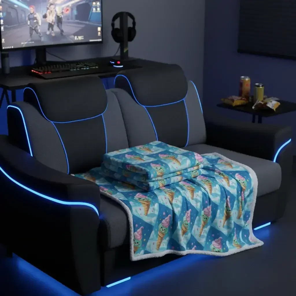 Gaming room with black and blue LED-lit sofa, folded ice cream patterned blanket, computer desk, and snacks