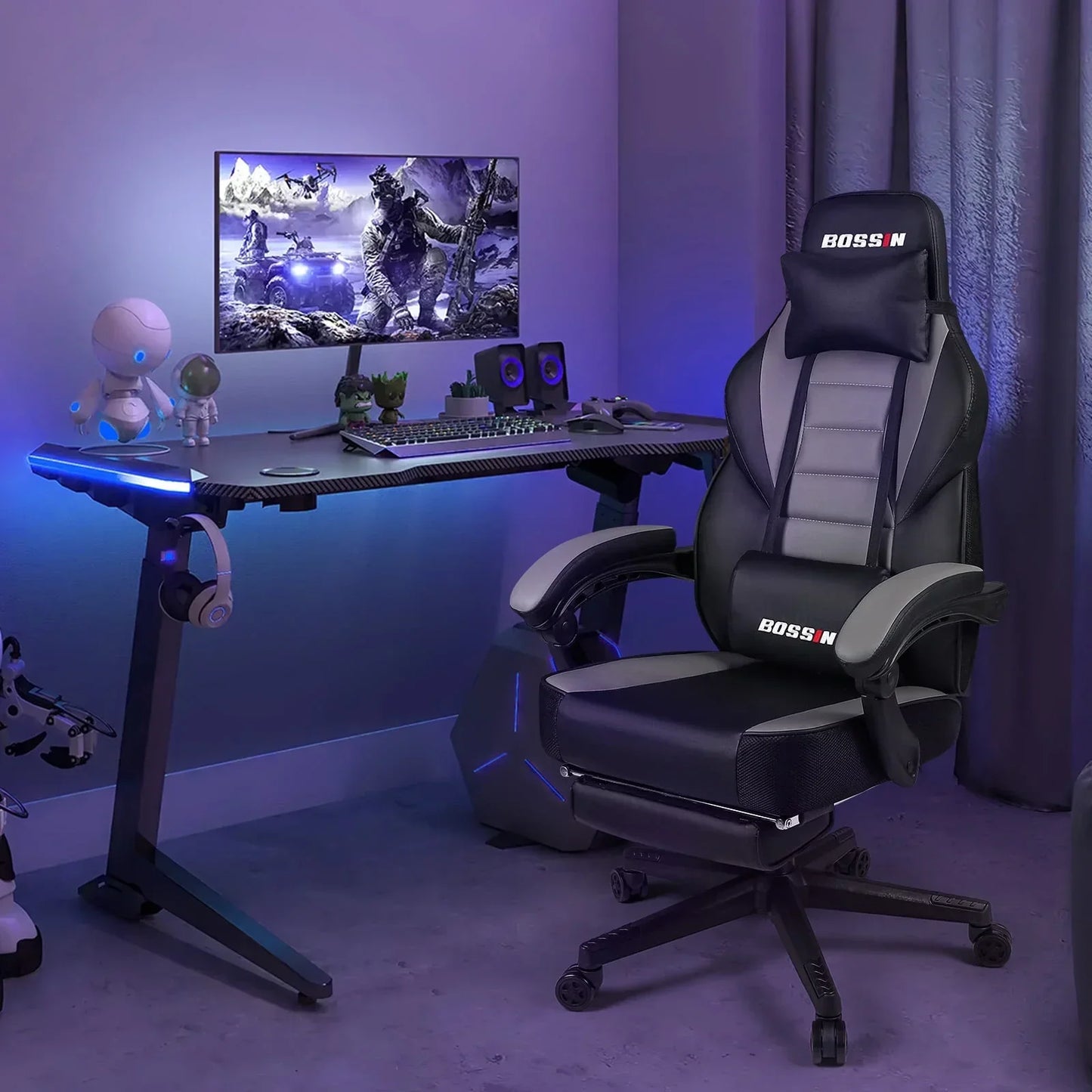 Modern gaming setup with Bossin ergonomic black and gray gaming chair, LED-lit desk, monitor displaying war game, gaming accessories