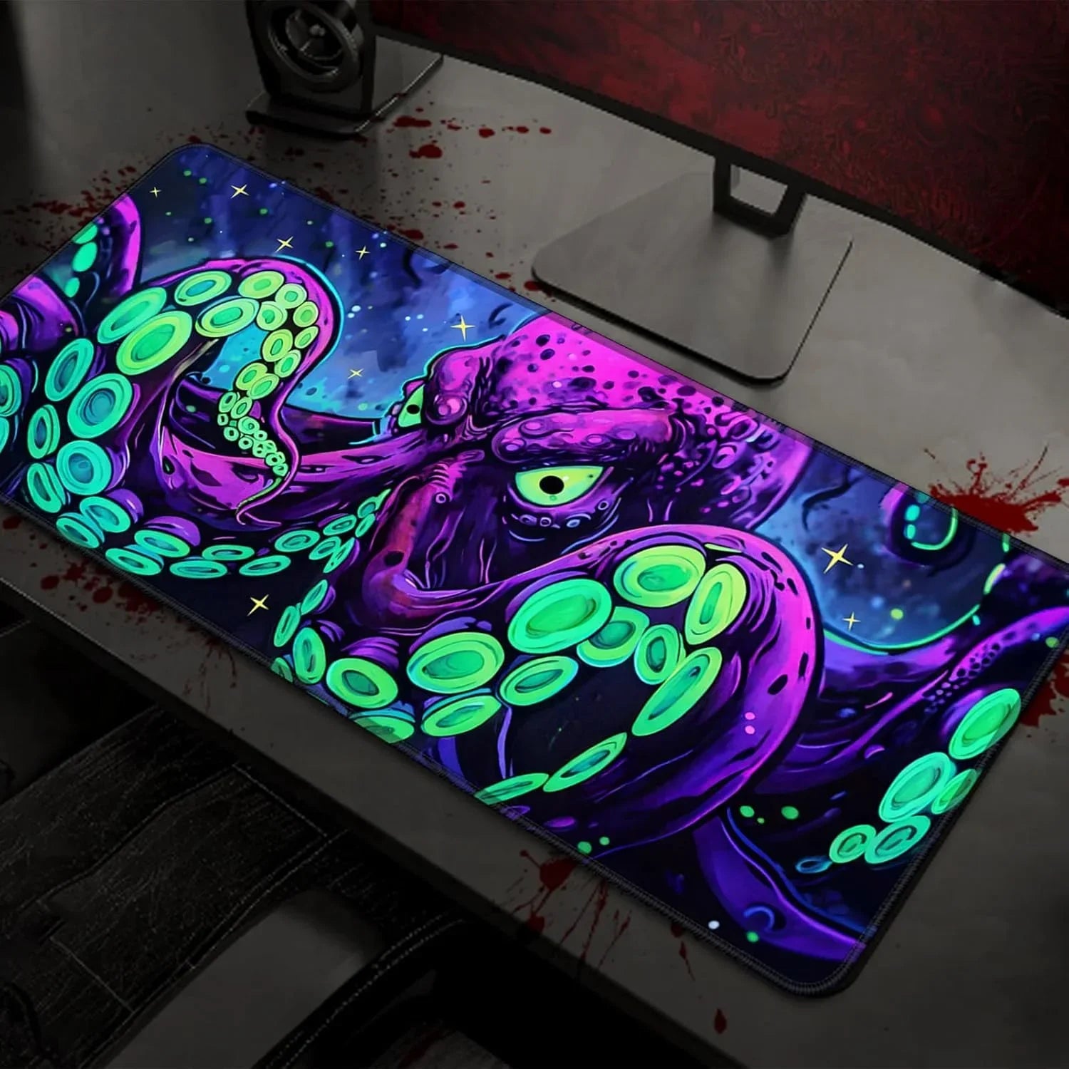 Gaming desk setup with colorful octopus-themed RGB mouse pad under a monitor stand