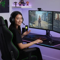 Young woman gamer with headset streaming video game on dual monitors in a modern gaming setup
