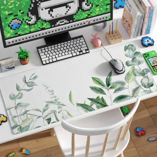 Gaming desk setup with leafy desk mat, retro mouse, keyboard, and pixel art decor