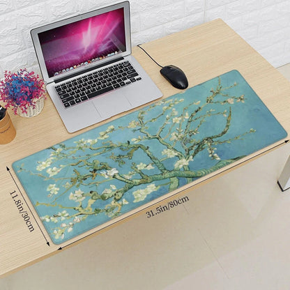 Desk with a laptop, black wired mouse, and a large gaming mouse pad featuring Van Gogh almond blossom art design
