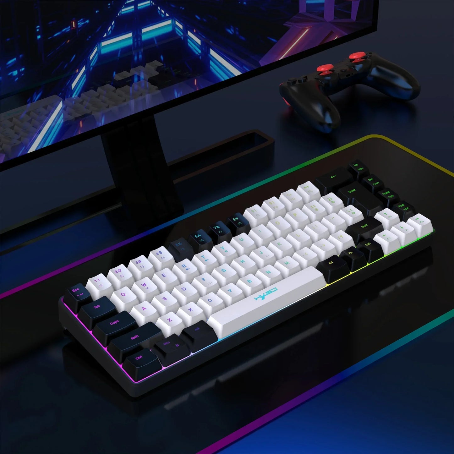 Mechanical gaming keyboard with white and black keycaps on an RGB mousepad next to a black gaming controller and monitor