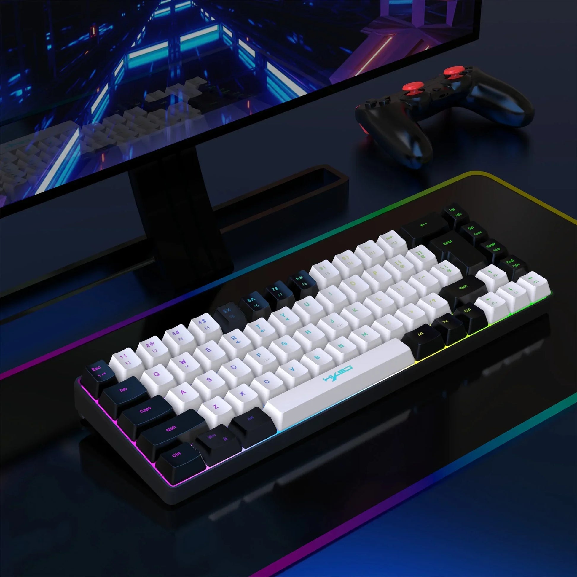 Mechanical gaming keyboard with white and black keycaps on an RGB mousepad next to a black gaming controller and monitor