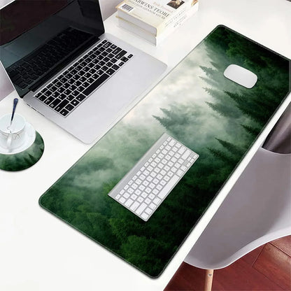 Modern laptop, white keyboard, and mouse on large gaming mouse pad with misty forest design on white desk
