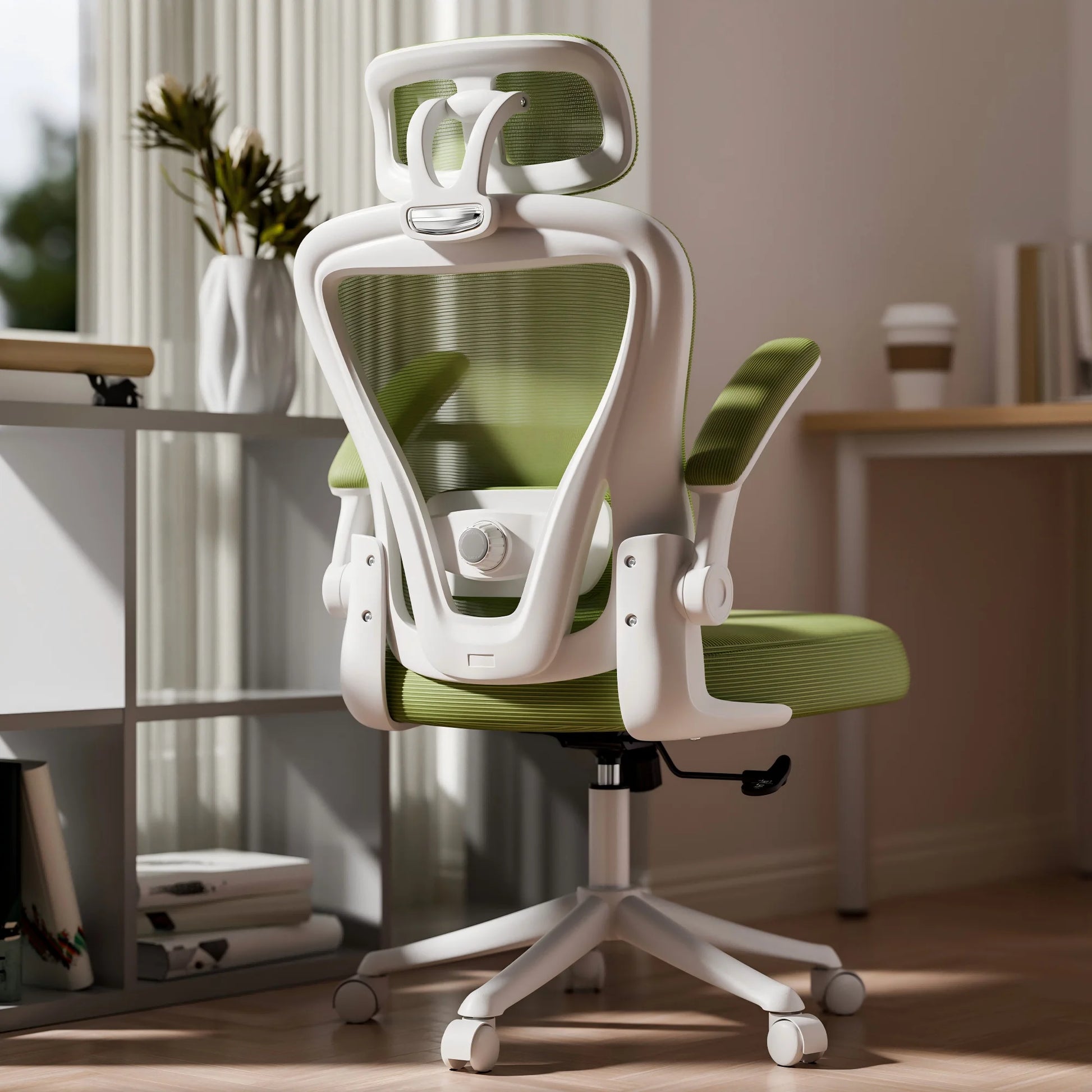 White and green ergonomic office chair with mesh back, headrest, and adjustable armrests in a bright home office