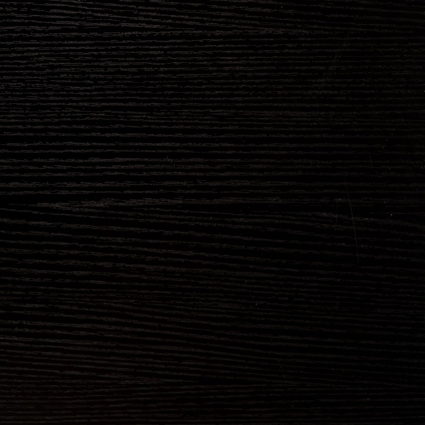 Close-up of dark black wood texture with visible grain patterns