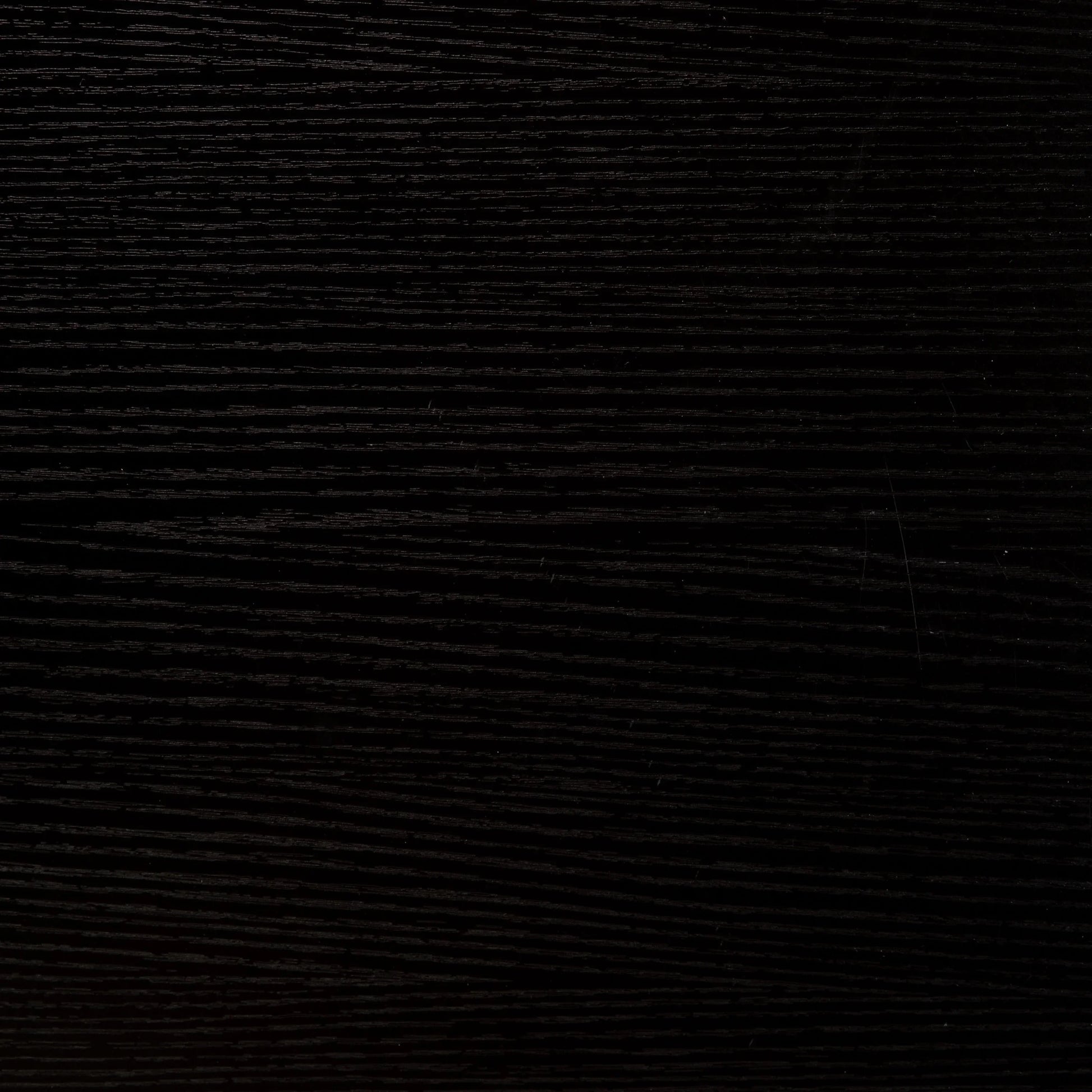 Close-up of dark black wood texture with visible grain patterns