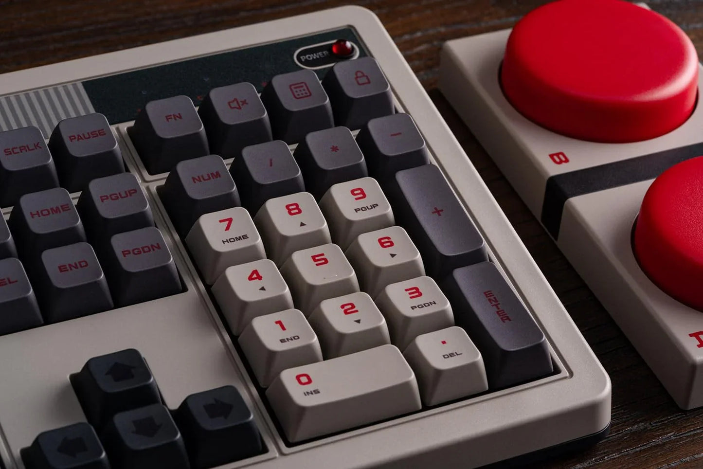 Retro 8-bit style mechanical keyboard with large red gaming buttons on a wooden desk