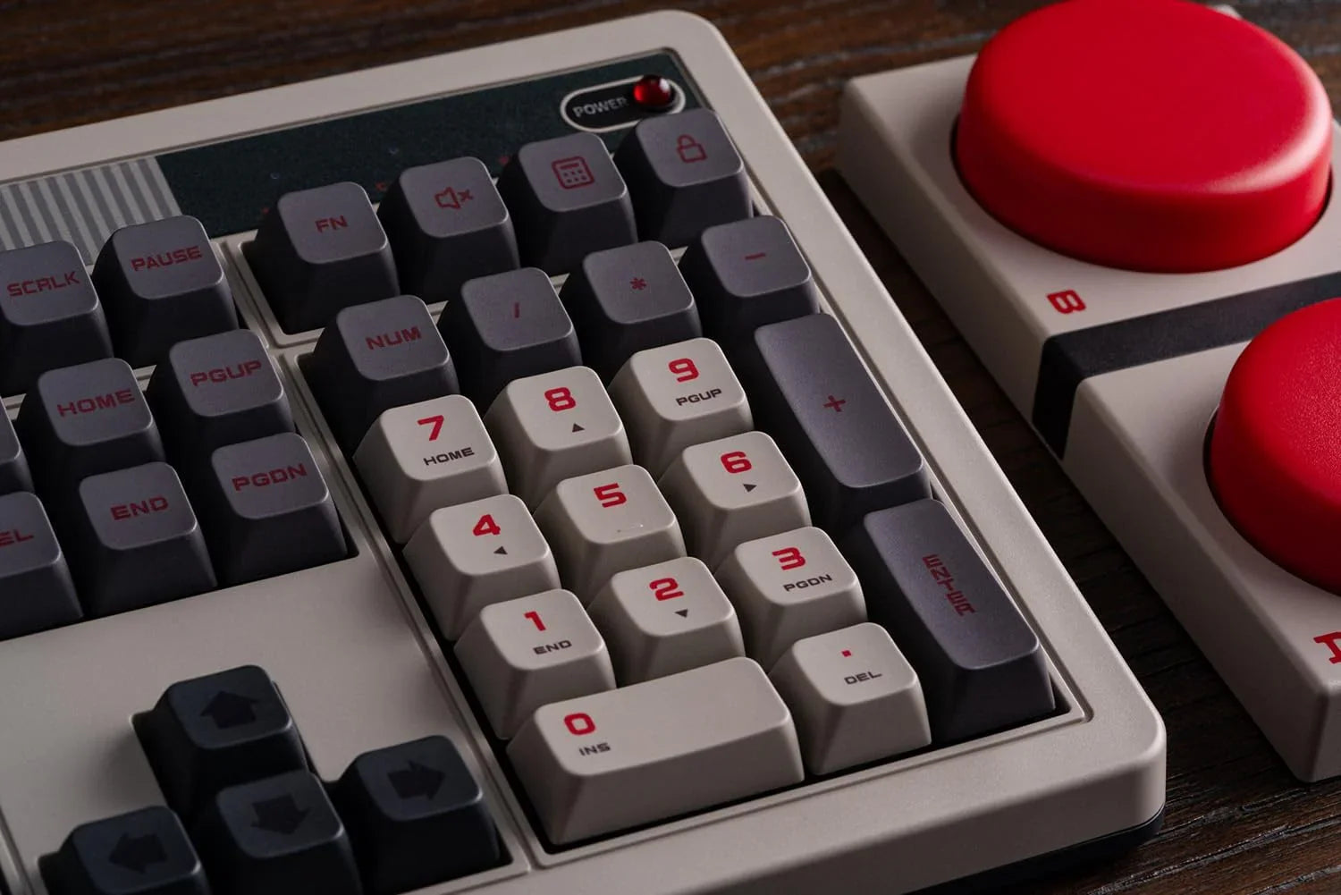 Retro 8-bit style mechanical keyboard with large red gaming buttons on a wooden desk