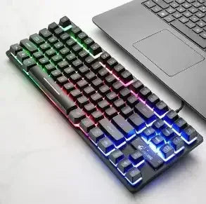 RGB backlit mechanical gaming keyboard connected to laptop on white desk