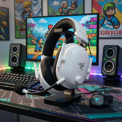 White gaming headset and pixelated mouse on a RGB-lit desk with retro gaming decor