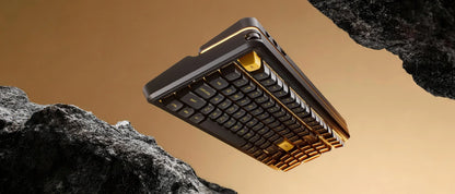 Black and gold gaming keyboard with retro 8-bit design floating between rocks, ideal for PC setup