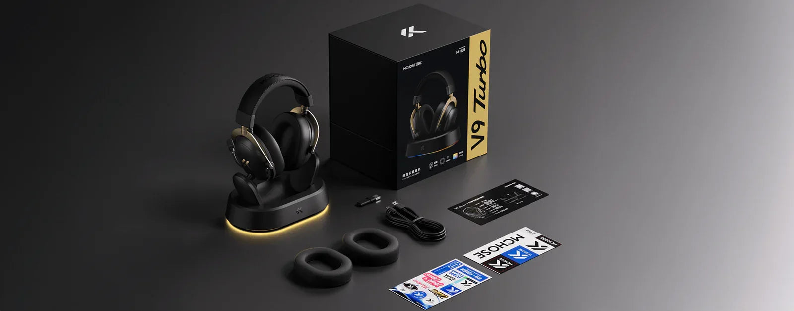 MCHOSE V9 Turbo wireless gaming headset with charging dock, ear cushions, and accessories on dark background