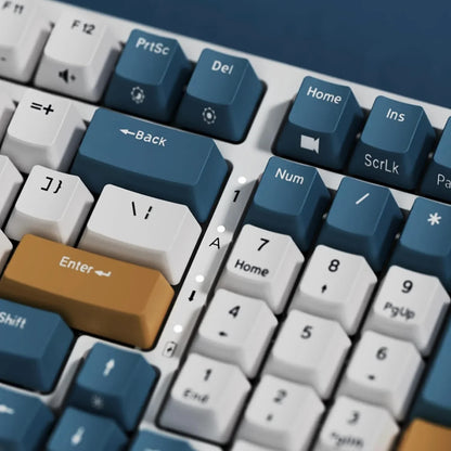 Close-up of retro gaming mechanical keyboard with blue, white, and orange keycaps and numpad