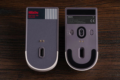 Bottom view of two retro-style 8BitDo wireless gaming mice on wooden surface