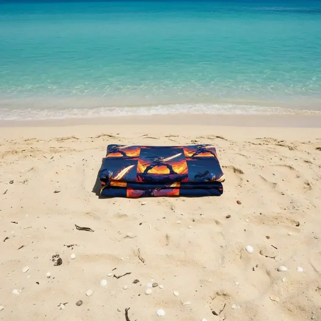 Folded Star Wars-themed blanket on sandy beach with turquoise ocean in background