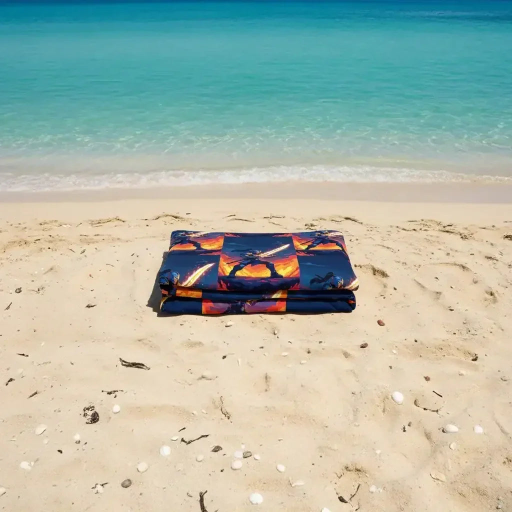 Folded beach towel with dragon design on sandy beach by turquoise sea