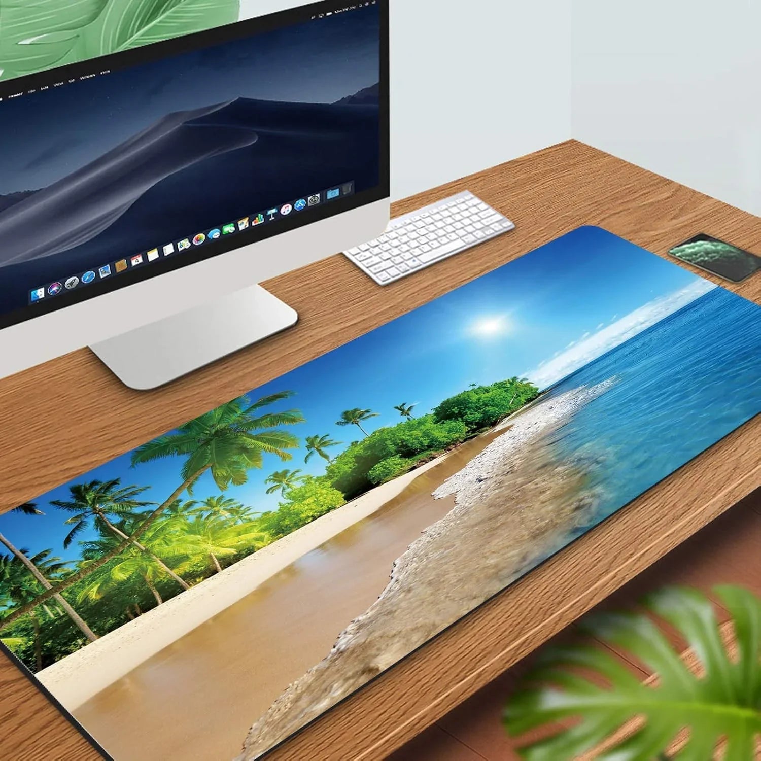 Gaming desk setup with large tropical beach scene mouse pad, white keyboard, and desktop monitor