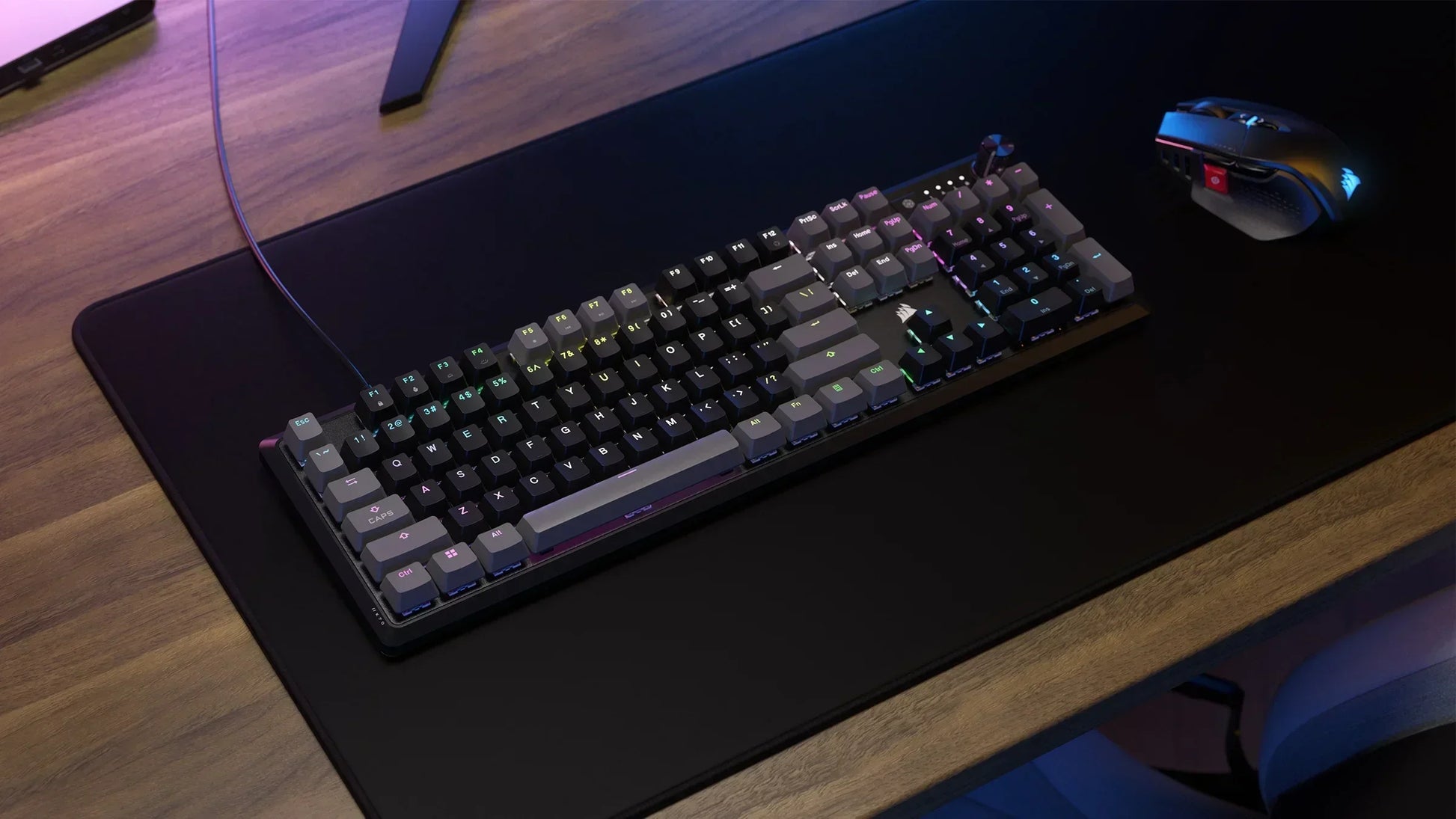 RGB mechanical gaming keyboard and mouse on a black desk mat, modern gaming setup