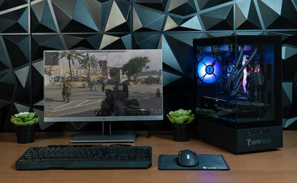 Gaming PC setup with RGB lighting, monitor displaying FPS game, keyboard, and mouse on desk
