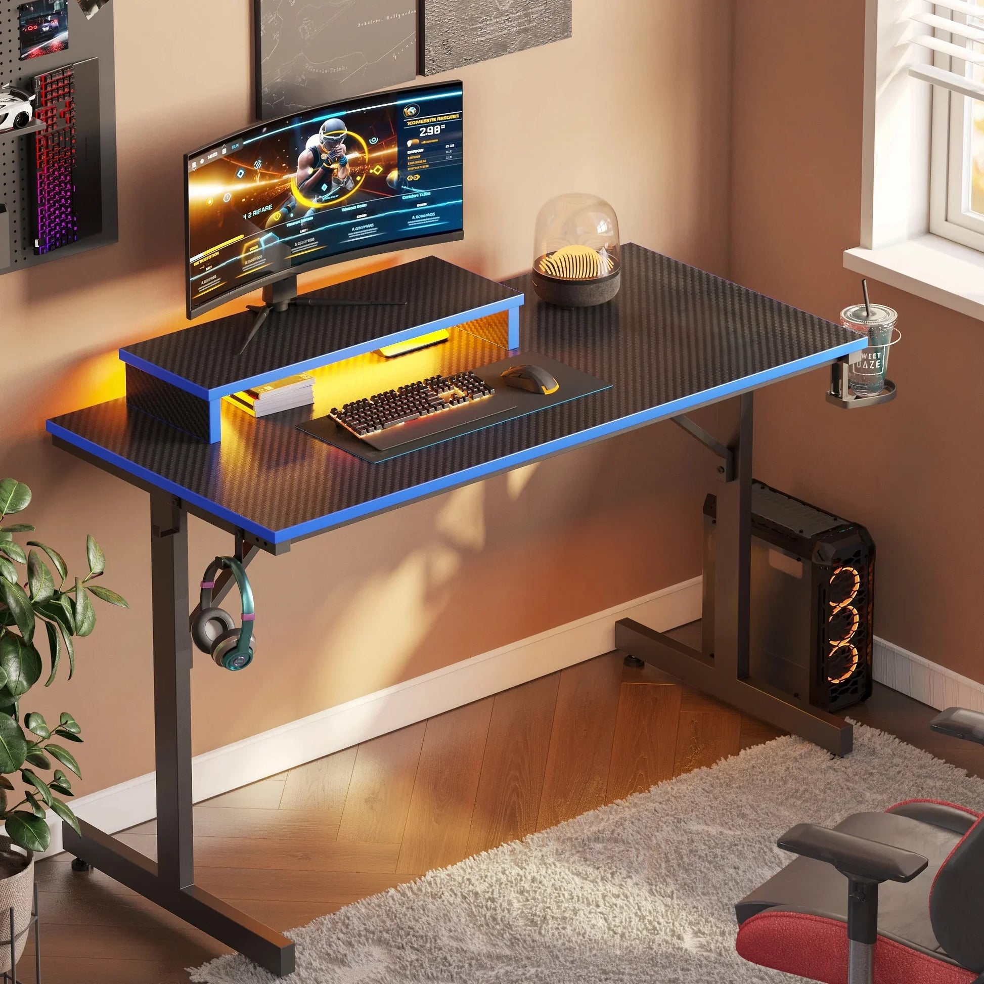 Modern curved gaming monitor on carbon fiber gaming desk with RGB keyboard and mouse, PC tower and headset