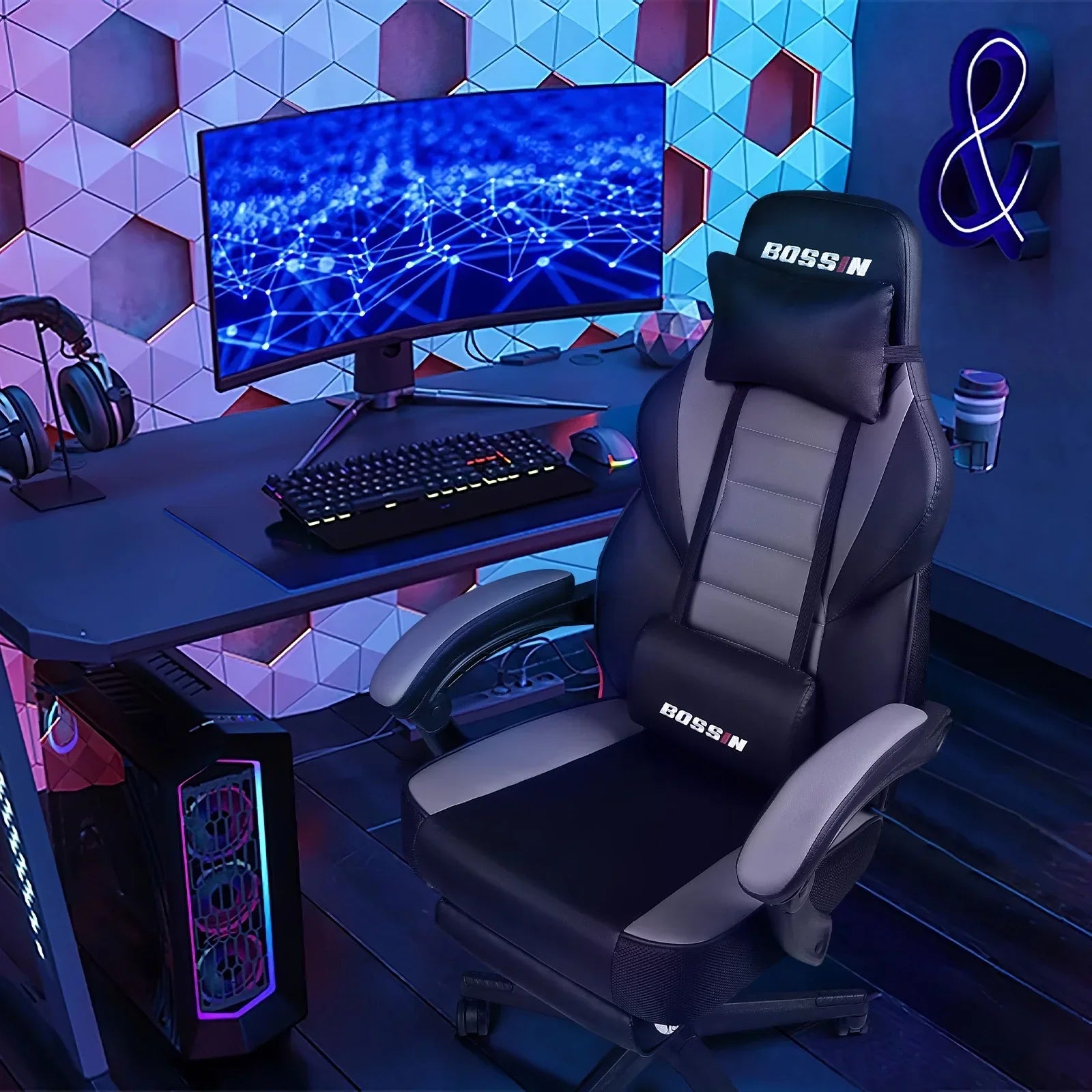 Ergonomic black and gray BOSSIN gaming chair in front of computer desk with curved monitor and RGB PC setup