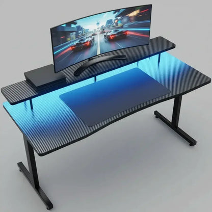 Modern gaming desk with carbon fiber texture, curved ultrawide monitor, blue LED lighting, and gaming console