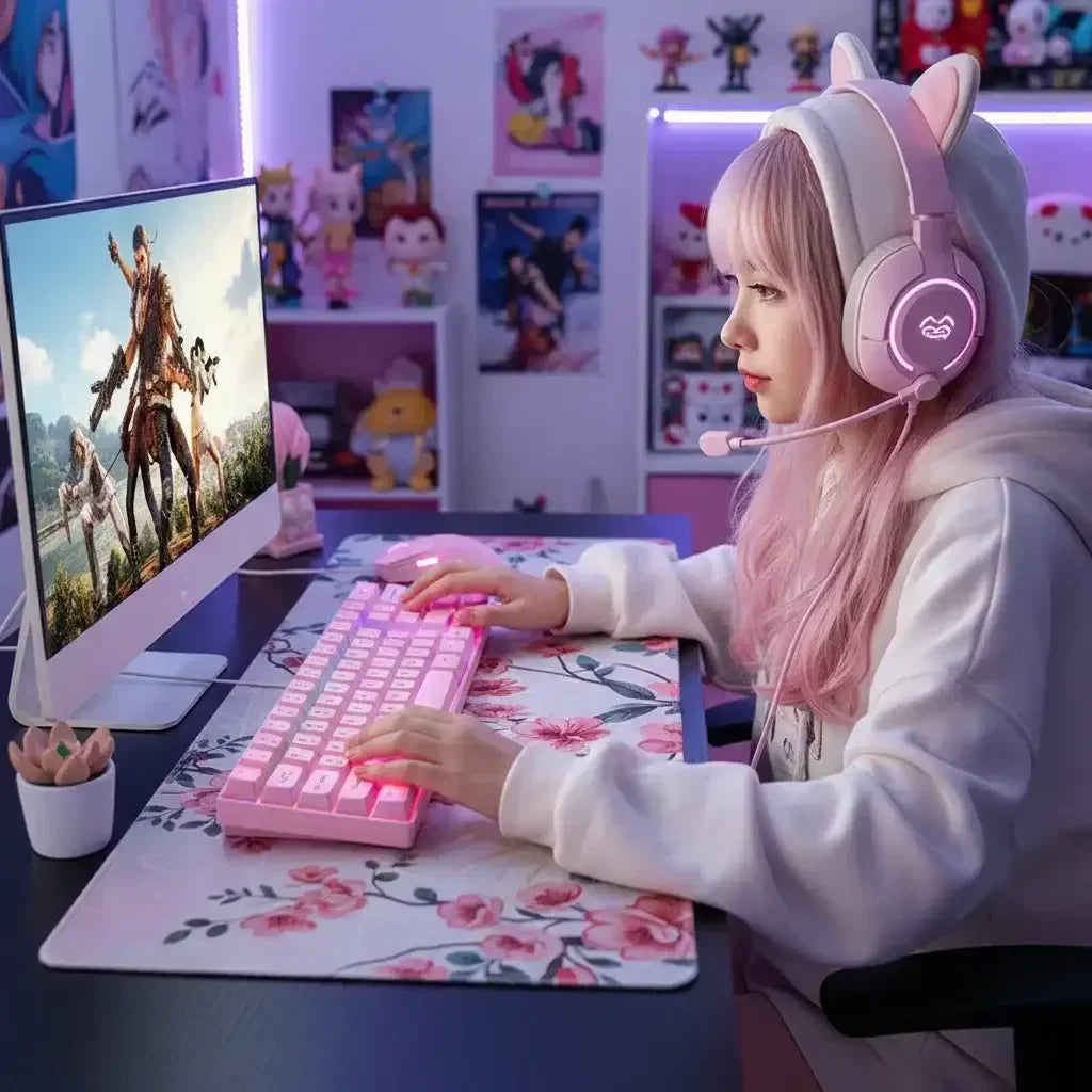 Gamer with pink hair wearing cat-ear headset using pink RGB keyboard and mouse in colorful gaming room