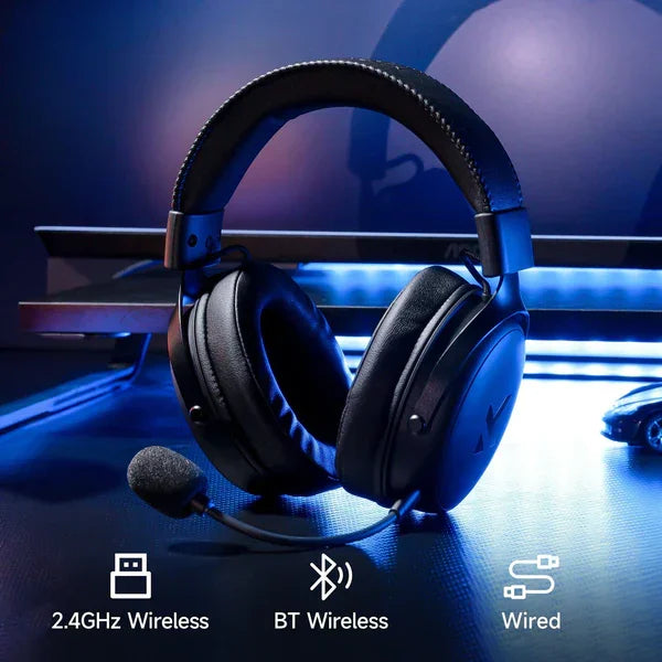Black gaming headset with mic, 2.4GHz, Bluetooth & wired connectivity, blue-lit desk setup