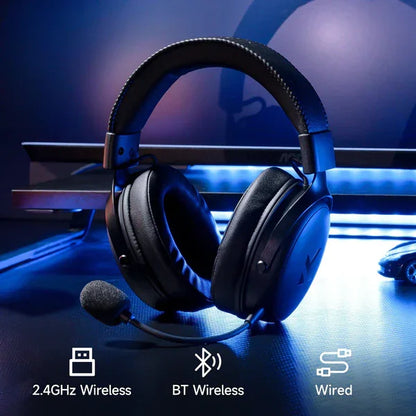 Black gaming headset with mic, 2.4GHz, Bluetooth & wired connectivity, blue-lit desk setup