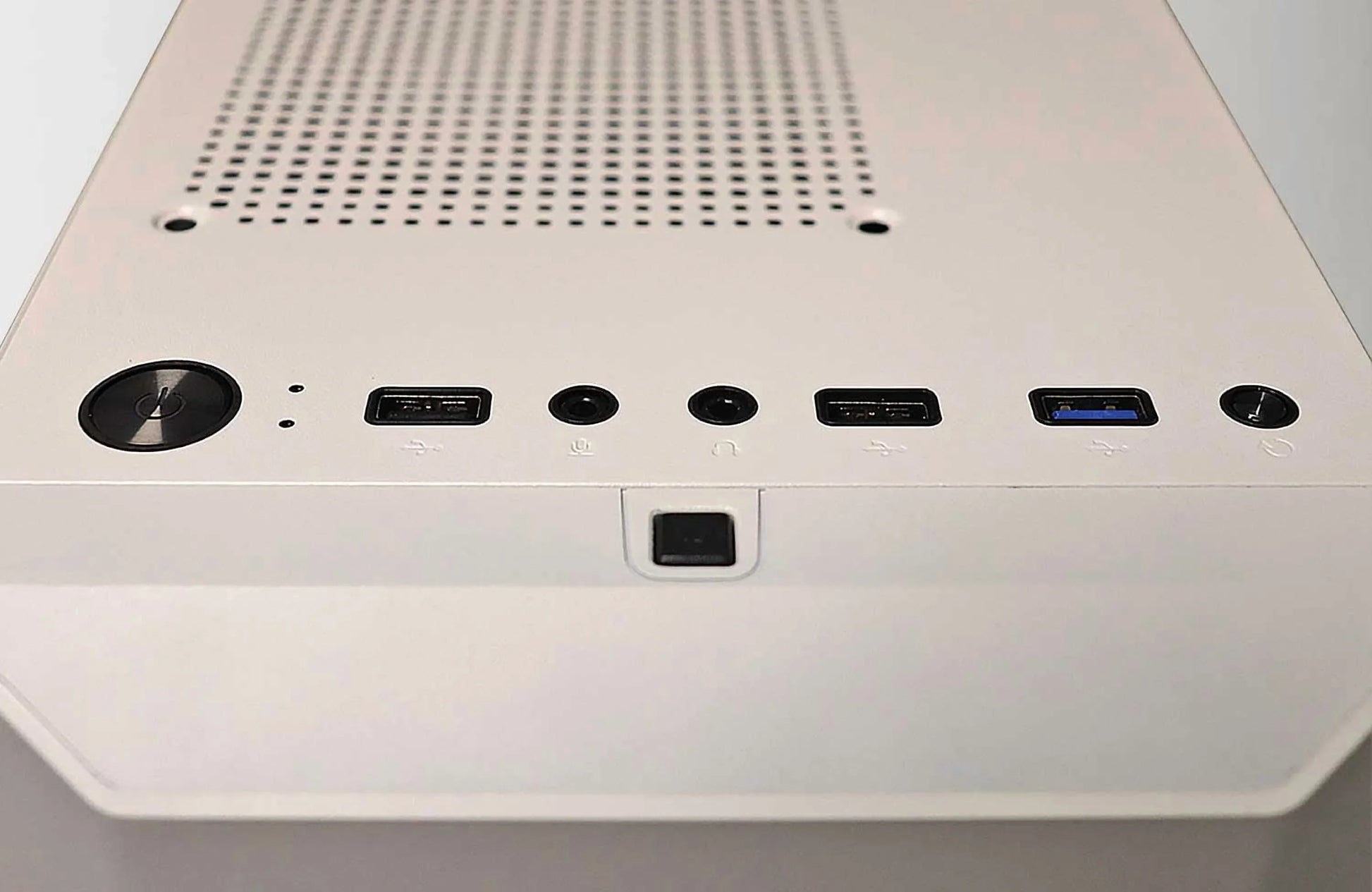 Close-up of white PC case top panel with power button, USB ports, headphone and microphone jacks