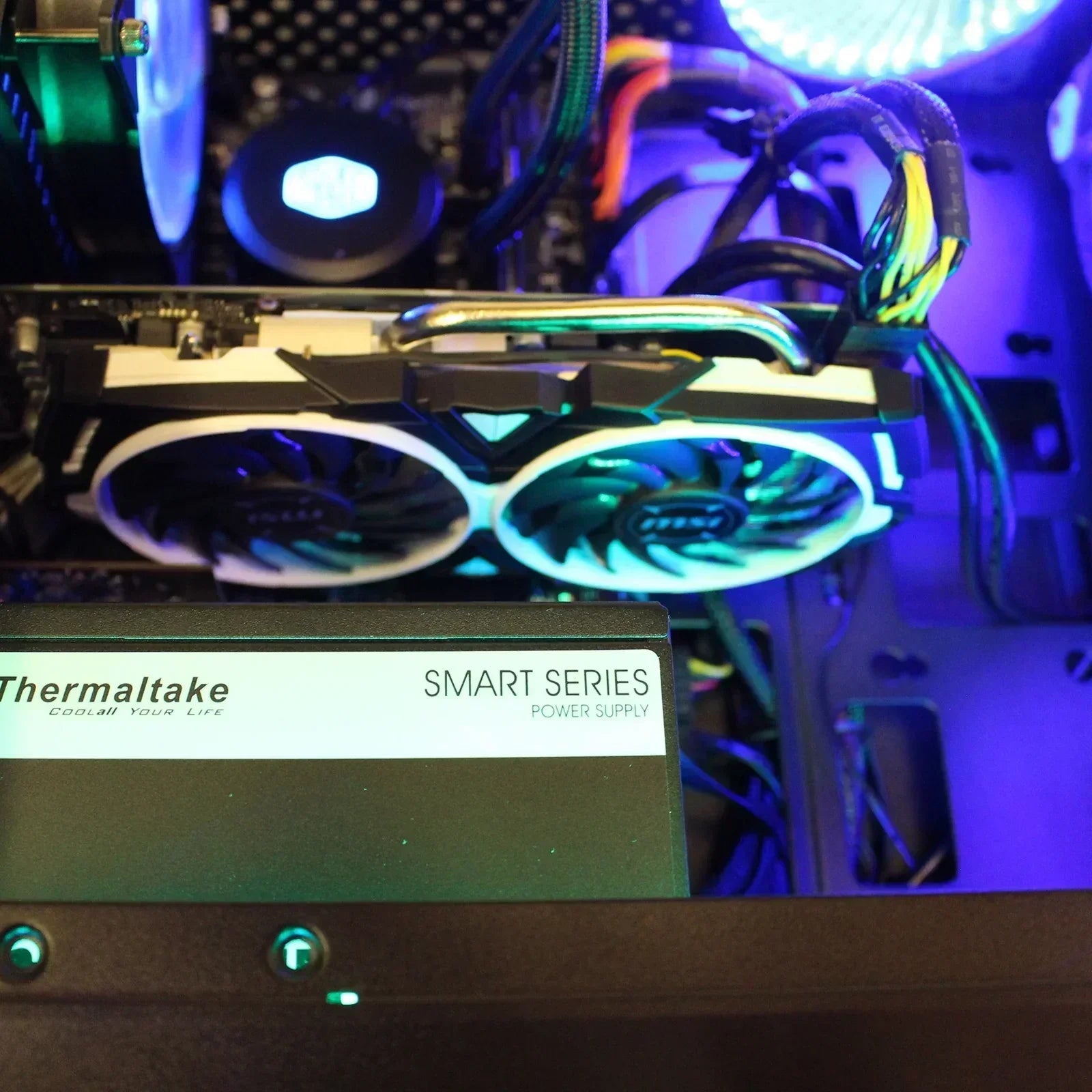 RGB-lit gaming PC interior with Thermaltake Smart Series power supply and dual-fan GPU