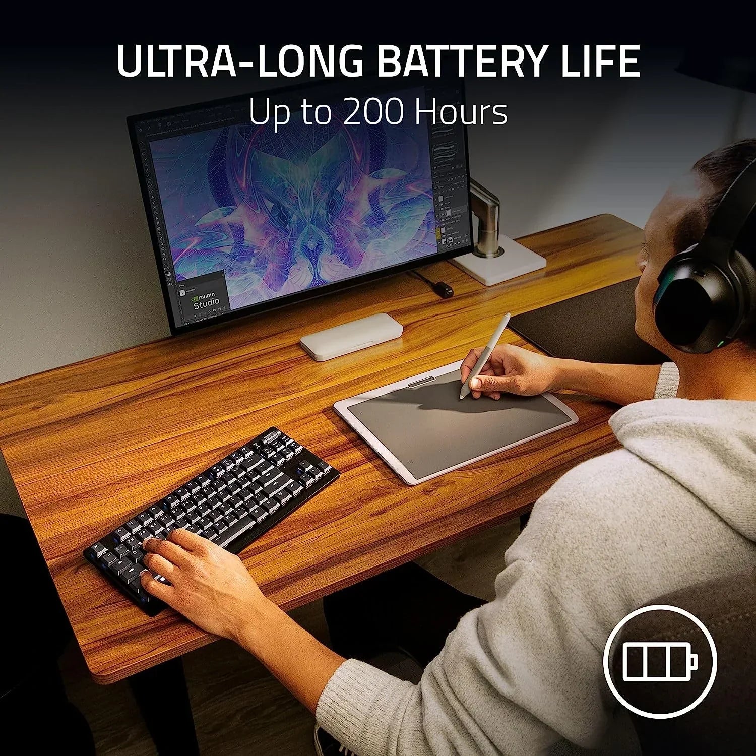 Person using gaming keyboard and graphics tablet at desk with ultra-long battery life display