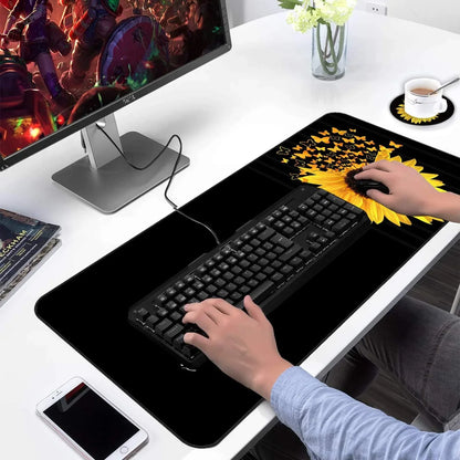 Gaming desk setup with sunflower and butterfly design extended mouse pad, mechanical keyboard, gaming monitor, and smartphone