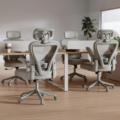 Ergonomic mesh office chairs with adjustable headrests at modern desks, ideal for gaming or work setups