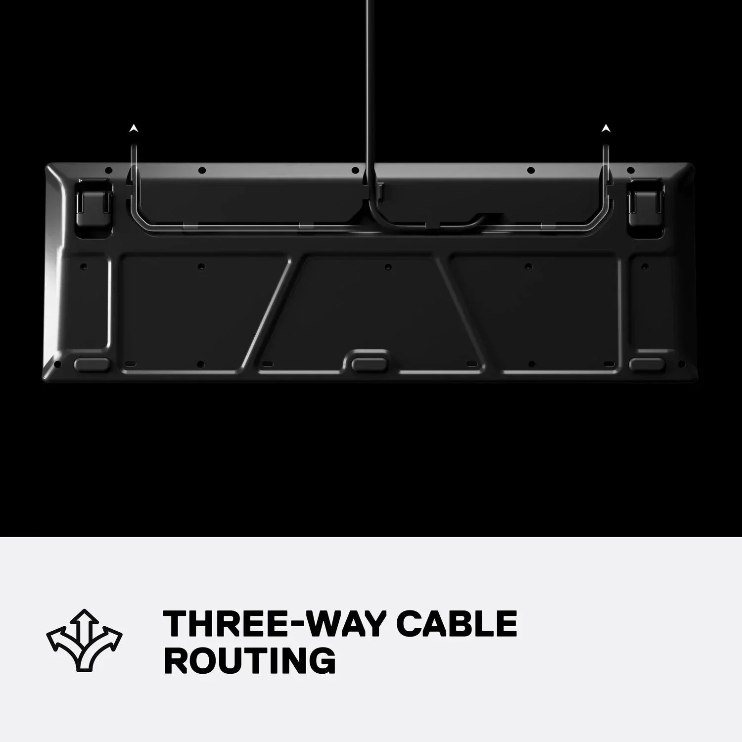 Black gaming keyboard underside showing three-way cable routing, modern desk setup feature