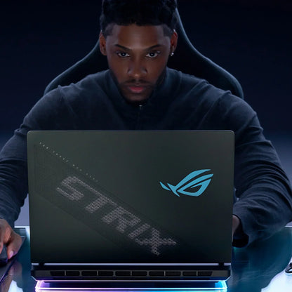 Gamer using ASUS ROG Strix laptop with LED logo in a dark gaming setup