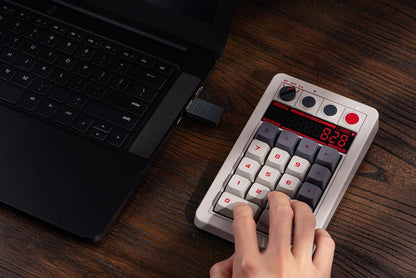 Retro 8-bit style mechanical keypad connected to laptop on wooden desk