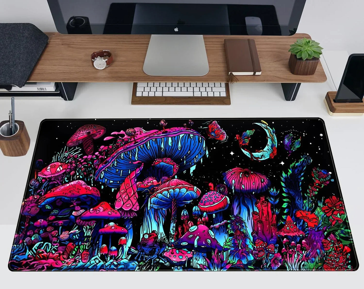 Colorful psychedelic mushroom and nature-themed desk mat on white desk with monitor, keyboard, and office accessories