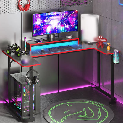 L-shaped gaming desk with RGB lighting, curved monitor, gaming keyboard, PC tower, and headphones